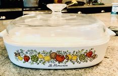 a casserole dish with fruit painted on the front and bottom, sitting on a kitchen counter