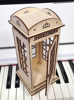 a paper model of a phone booth sitting on top of a piano