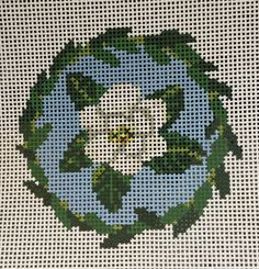 a cross - stitch picture of the earth with green leaves on it's surface