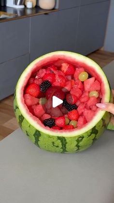 a watermelon bowl filled with lots of fruit