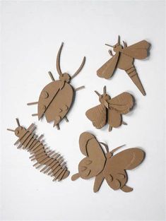 four pieces of cardboard cut out to look like insects