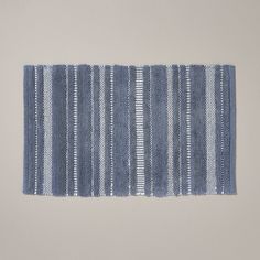 a blue and white striped rug on a gray wall