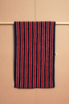 a red and blue striped towel hanging on a wall