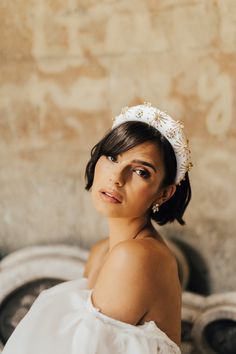 a woman wearing a white dress and headpiece