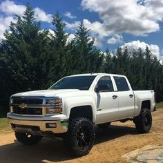 a white truck parked on top of a dirt road