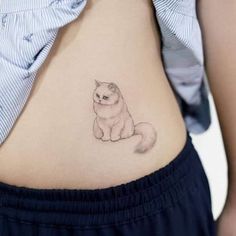 a woman's stomach with a small tattoo of a cat on the side of her belly