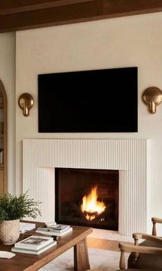 a living room with a fire place and tv above the fireplace in front of it