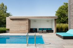 an empty swimming pool with lounge chairs next to it