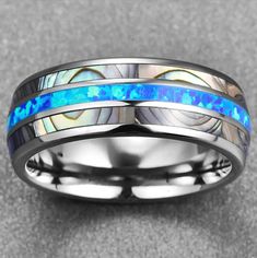 a wedding ring with blue and white opal inlays on the inside of it