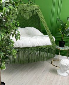 a green chair sitting next to a potted plant