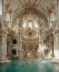 an indoor swimming pool with people in the water and statues on the wall around it