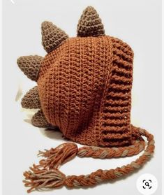 a crocheted brown hat with horns and tassels