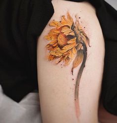 a sunflower tattoo on the left upper arm