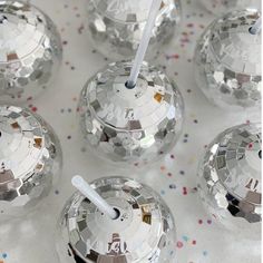 several disco balls with a white straw sticking out of them