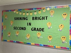 a bulletin board that says shining bright in second grade with light bulbs and smiley faces