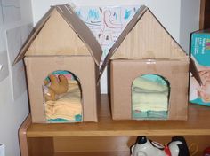 two cardboard houses sitting on top of a wooden shelf