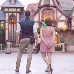 a man and woman walking in front of a house