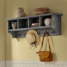 a hat and purse are hanging on a wall with shelves above it that hold hats