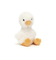 a small white stuffed duck sitting on top of a white floor next to a wall