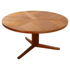 a round wooden table with four cross legs