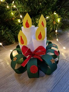 a christmas wreath made out of toilet paper with lit candles on it and ribbon around the edges