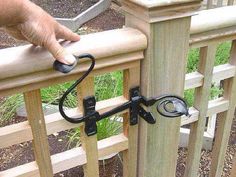 a hand is holding the handle on a wooden railing