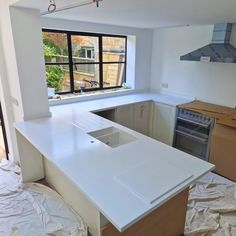 an empty kitchen with white counter tops in the process of remodeling it