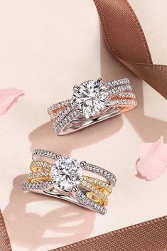 two different colored gold and silver wedding rings with diamonds on the sides, one in between