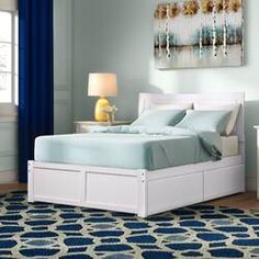 a bedroom with blue and white decor, including a large painting on the wall above the bed