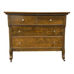 a wooden dresser with three drawers and two pulls on the bottom drawer, against a white background