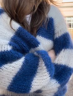 a woman wearing a blue and white striped sweater