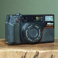 an old camera sitting on top of a wooden table