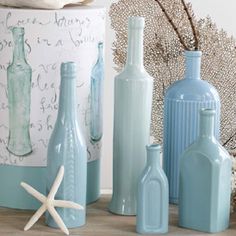 blue vases and starfish are on the table next to a box with writing