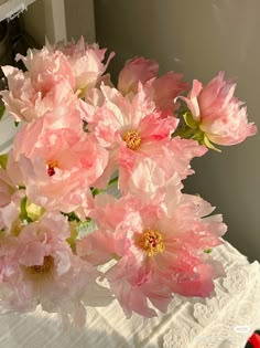 some pink flowers are in a vase on a table