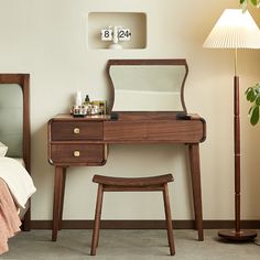 a bedroom scene with focus on the dressing table and mirror, which is next to a bed