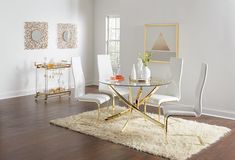 a glass table with white chairs and a rug in front of it on the floor