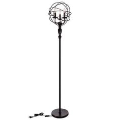 a black metal floor lamp with three candles on it's base and an electric outlet plugged in