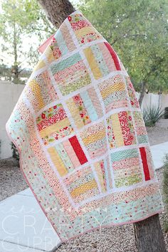 a quilt hanging from a tree in the yard