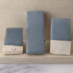 three blue and white vases sitting on top of a shelf