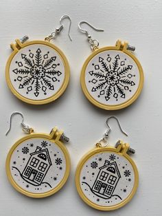 three embroidery hoop earrings with houses and snowflakes