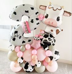 the balloon sculpture is made to look like a cow and has balloons attached to it