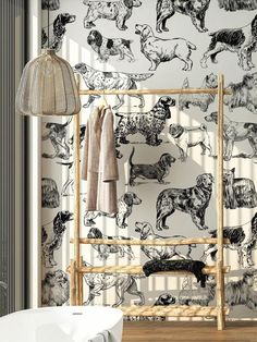 a wall with dogs on it next to a lamp and towel rack in a bathroom