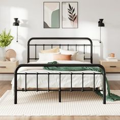 a black metal bed frame in a white bedroom with wood flooring and artwork on the wall