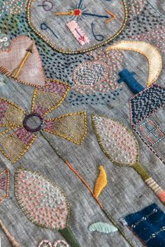 a close up of a piece of cloth with embroidered flowers and clocks on the side