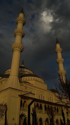 a large white building with two towers under a cloudy sky