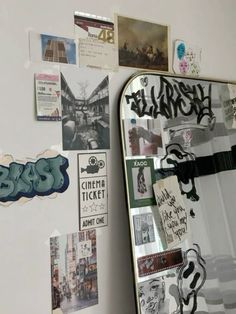 a skateboard is propped up against a wall covered with posters and stickers on it