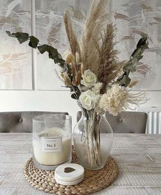 a vase with flowers and candles on a table