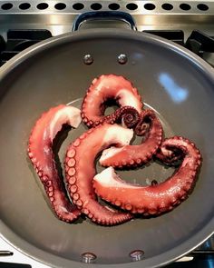 an octopus is cooking in a pan on the stove