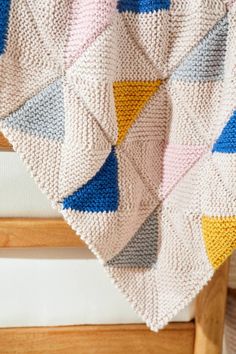 a crocheted blanket on top of a wooden chair