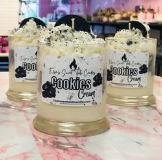 three candles sitting on top of a table covered in white frosting and black cookies